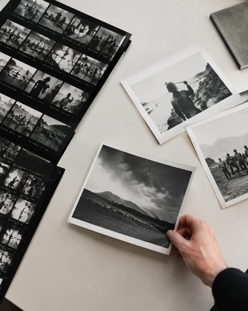 Black and white contact sheets and prints on a studio table